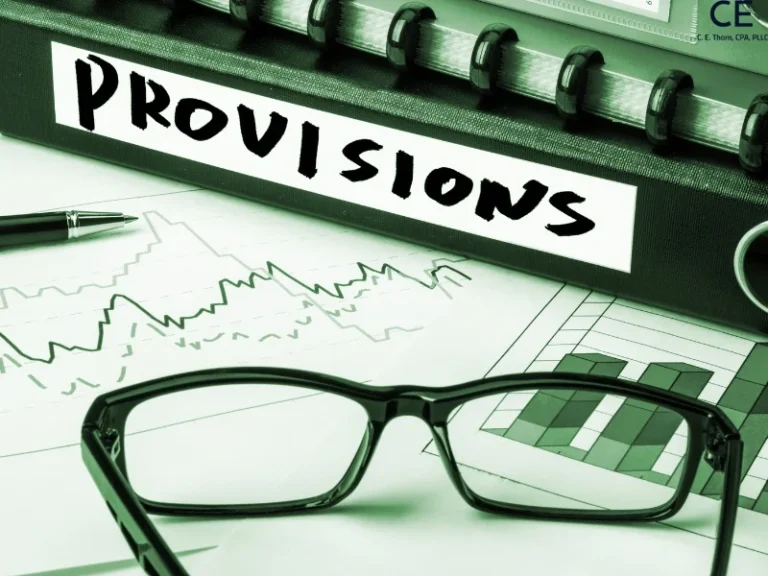 A binder, a line graph, and a pair of glasses are shown sitting on a table. This image is for the blog post titled, "What is a tax provision?"